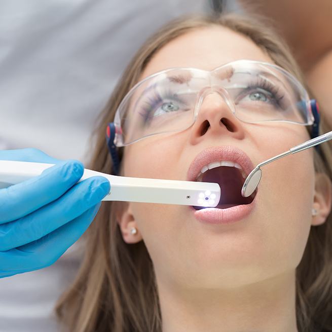 Dentist using intraoral camera to capture images of patient's smile