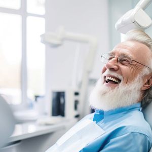 Happy older man in dental treatment chair