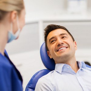 smiling patient who accepts that implant dentures are more expensive 